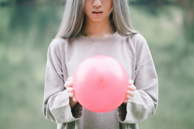 Woman holding balloon between her hands