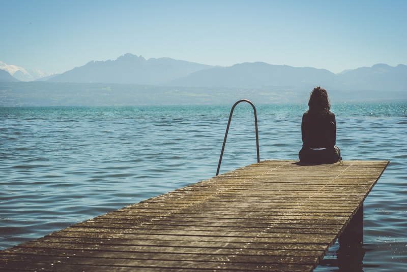 Discouraged woman sitting on dock