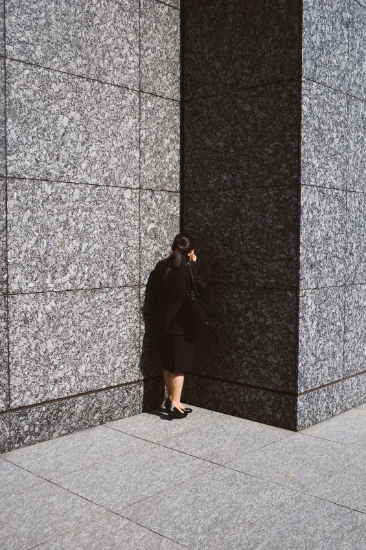 Woman facing a stone wall
